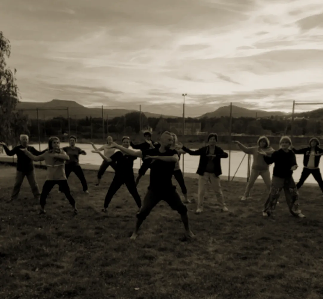 Grupo practicando al atardecer con las montañas al fondo